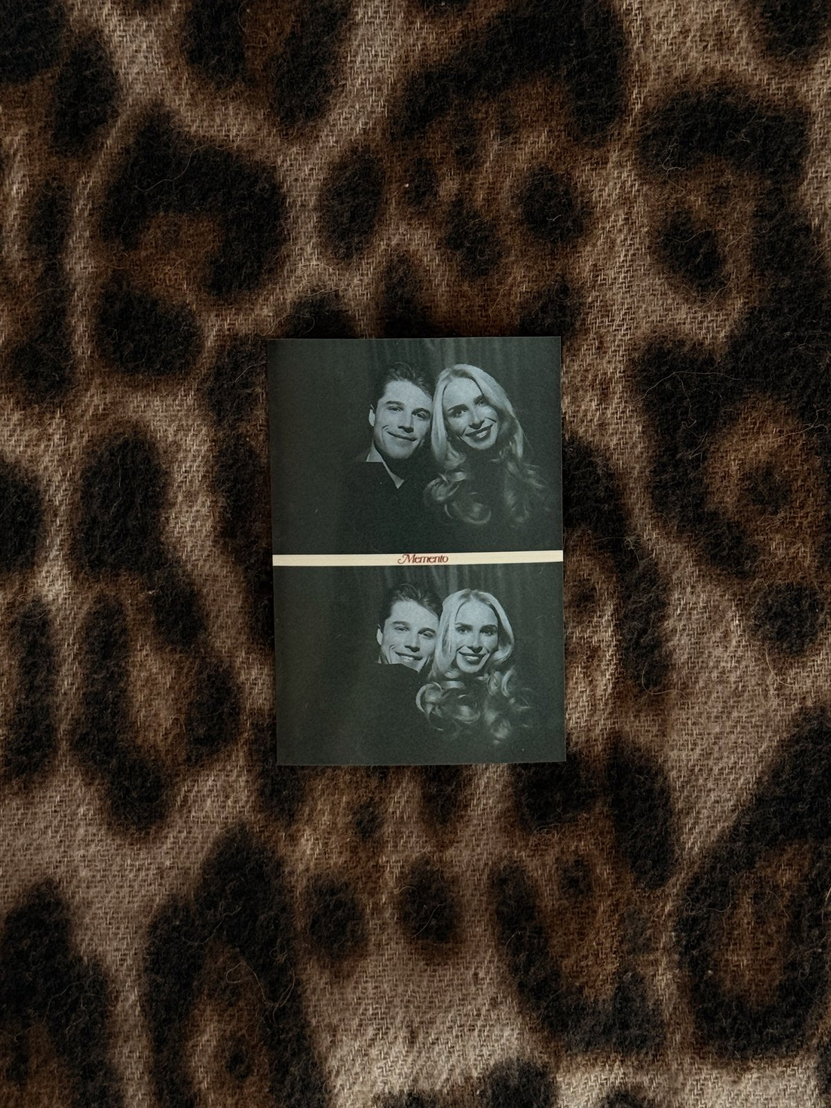 A Memento photo card resting on leopard print fabric