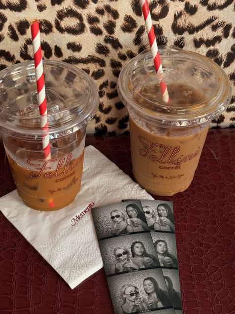 Two iced coffees and photo strips on a Memento napkin against leopard print.